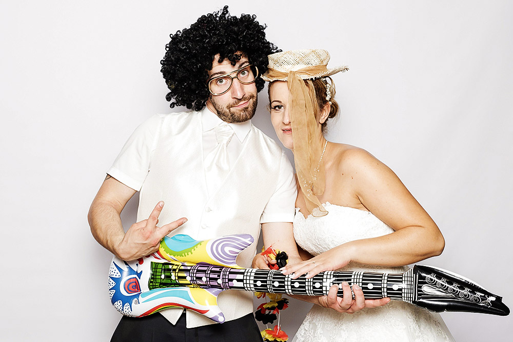 Brautpaar mit Luftgitarre und lustigen Kopfbedeckungen